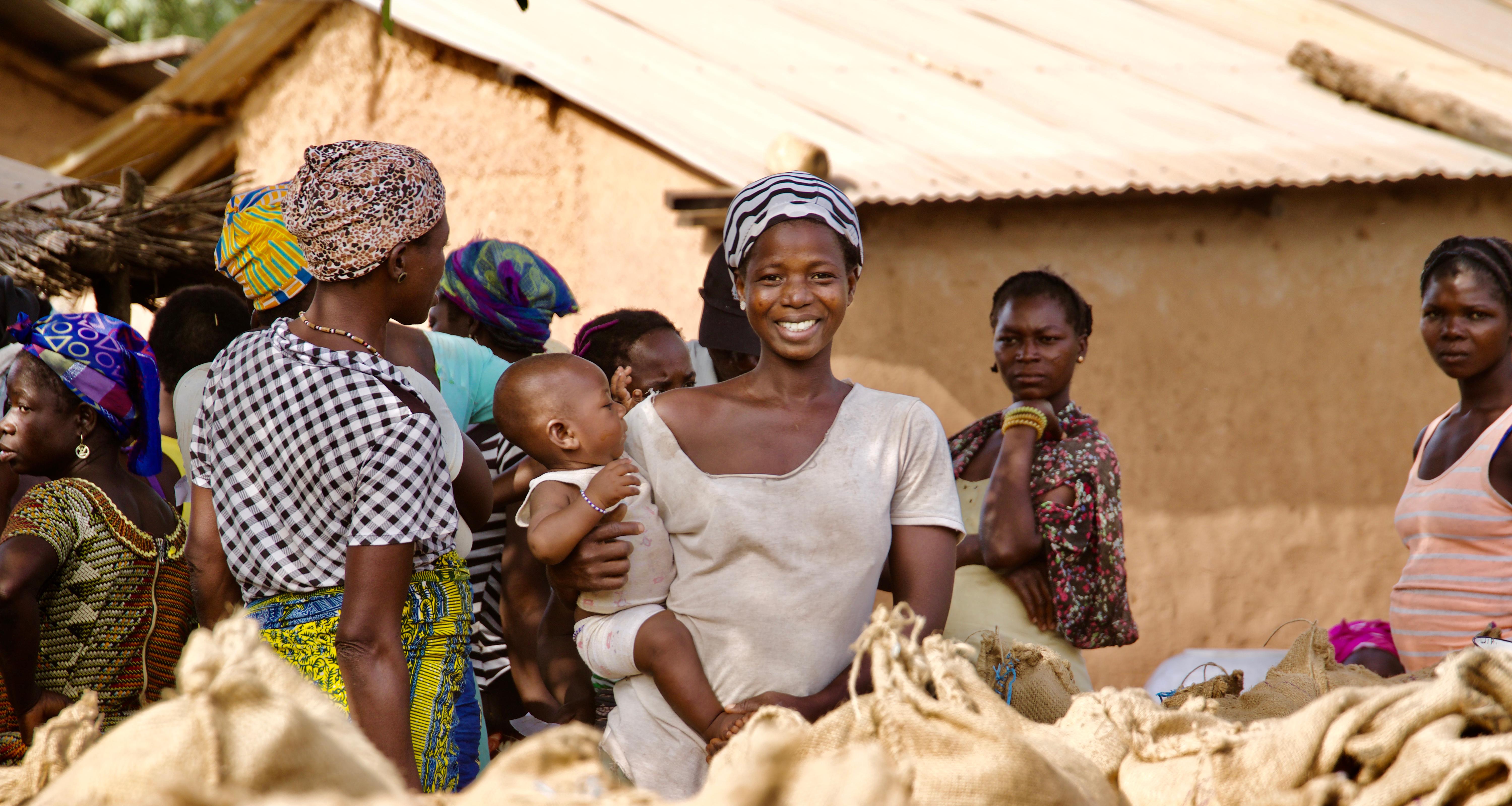 West african woman holding her baby while smiling.