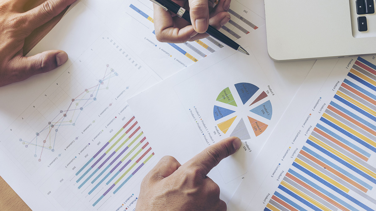 Hand som håller penna som pekar på utskrivna diagram - Technical Products - AAK