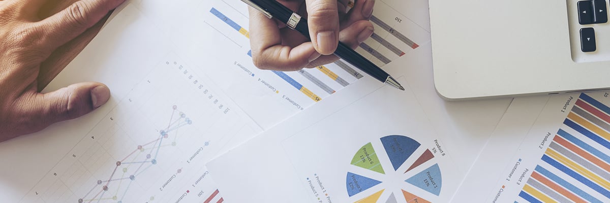 Hand som håller penna som pekar på utskrivna diagram - Technical Products - AAK