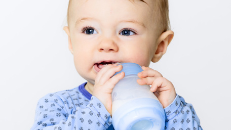 Ett litet barn som dricker från en nappflaska - Special Nutrition - AAK
