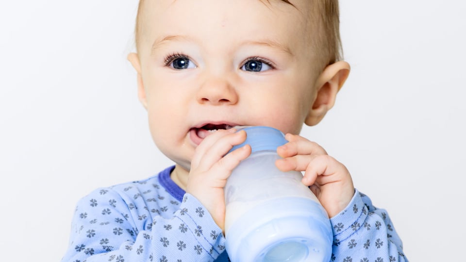 Ett litet barn som dricker från en nappflaska - Special Nutrition - AAK