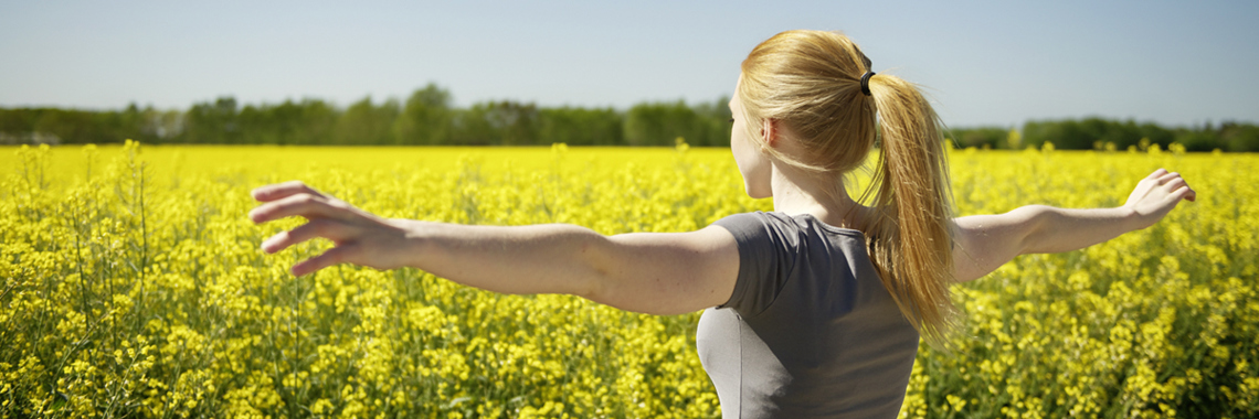 Woman standing in front of rapeseed field - Special Nutrition - AAK
