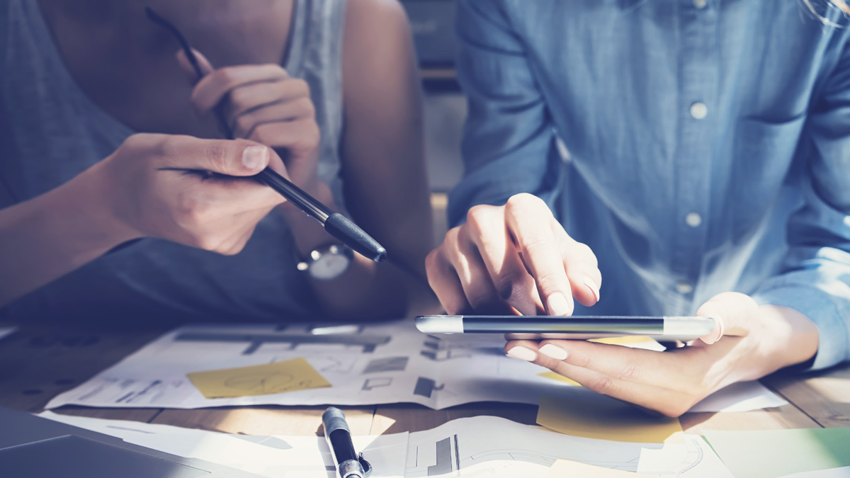 Two Female Co-Workers with Tablet and Financial Documents - Investors - AAK