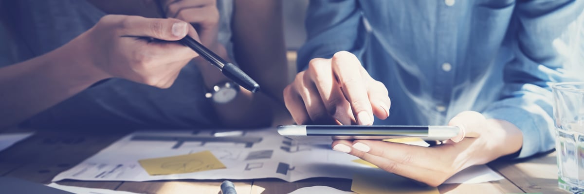 Två kvinnliga kollegor med surfplatta och finansiella dokument - Investerare - AAK