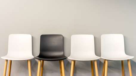 Rad med stolar i olika färger längs en vägg - Investerare - AAK