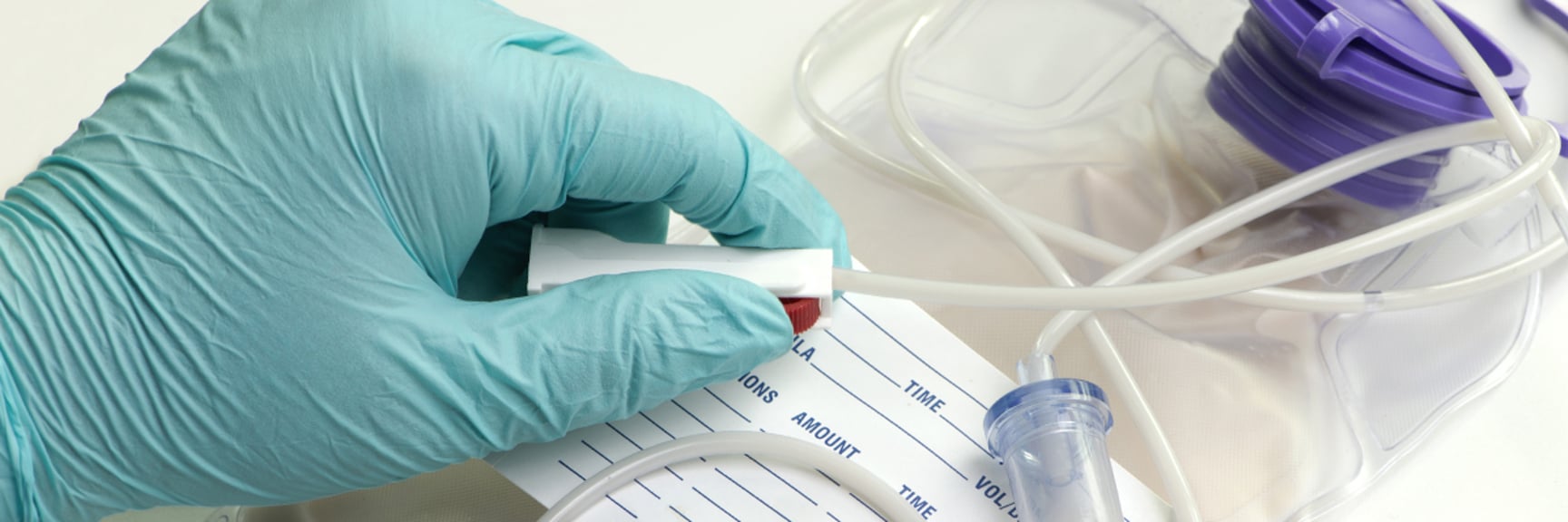 Hand in surgeon glove holding IV - Special Nutrition - AAK