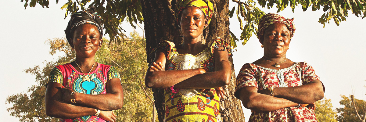 Three smiling women with folded arms in Burkina Faso - News & Stories - AAK