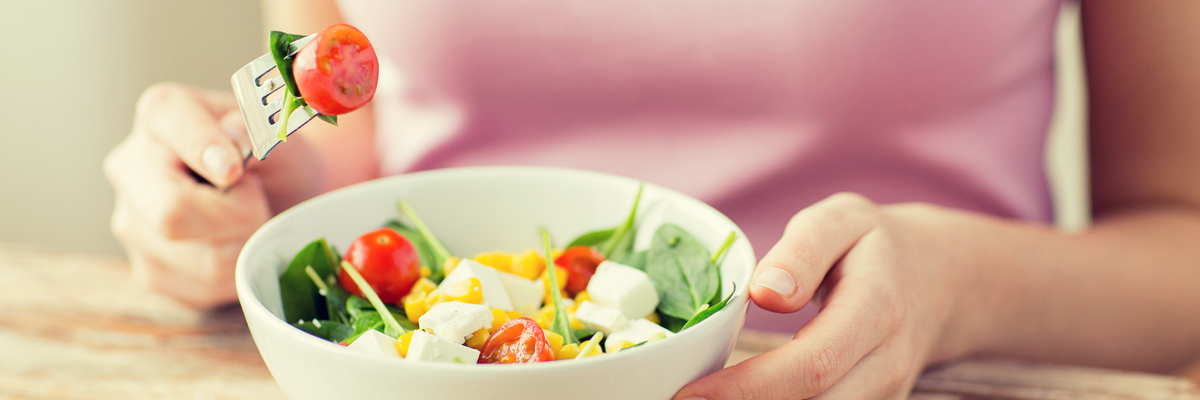 Woman in front a bowl of vegetables and feta cheese - Special Nutrition - AAK