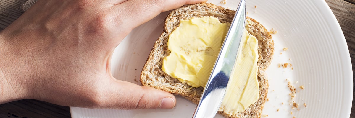 Någon brer smör på en skiva bröd - Mejeriprodukter och glass - AAK