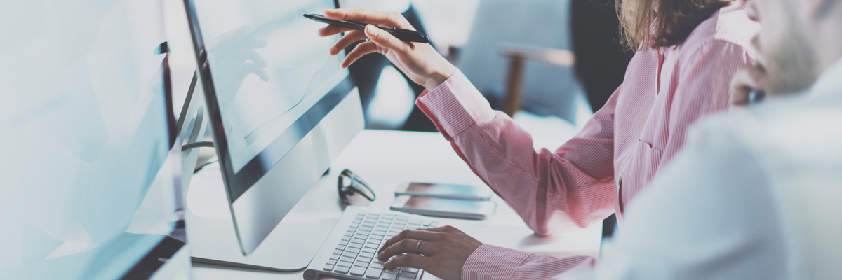 Arbetskamrater som pekar på skärm med finansiell information - Investerare - AAK