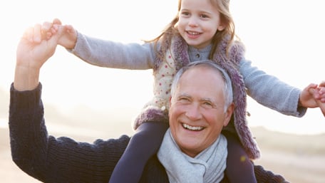 En glad flicka som sitter på en äldre mans axlar - Special Nutrition - AAK