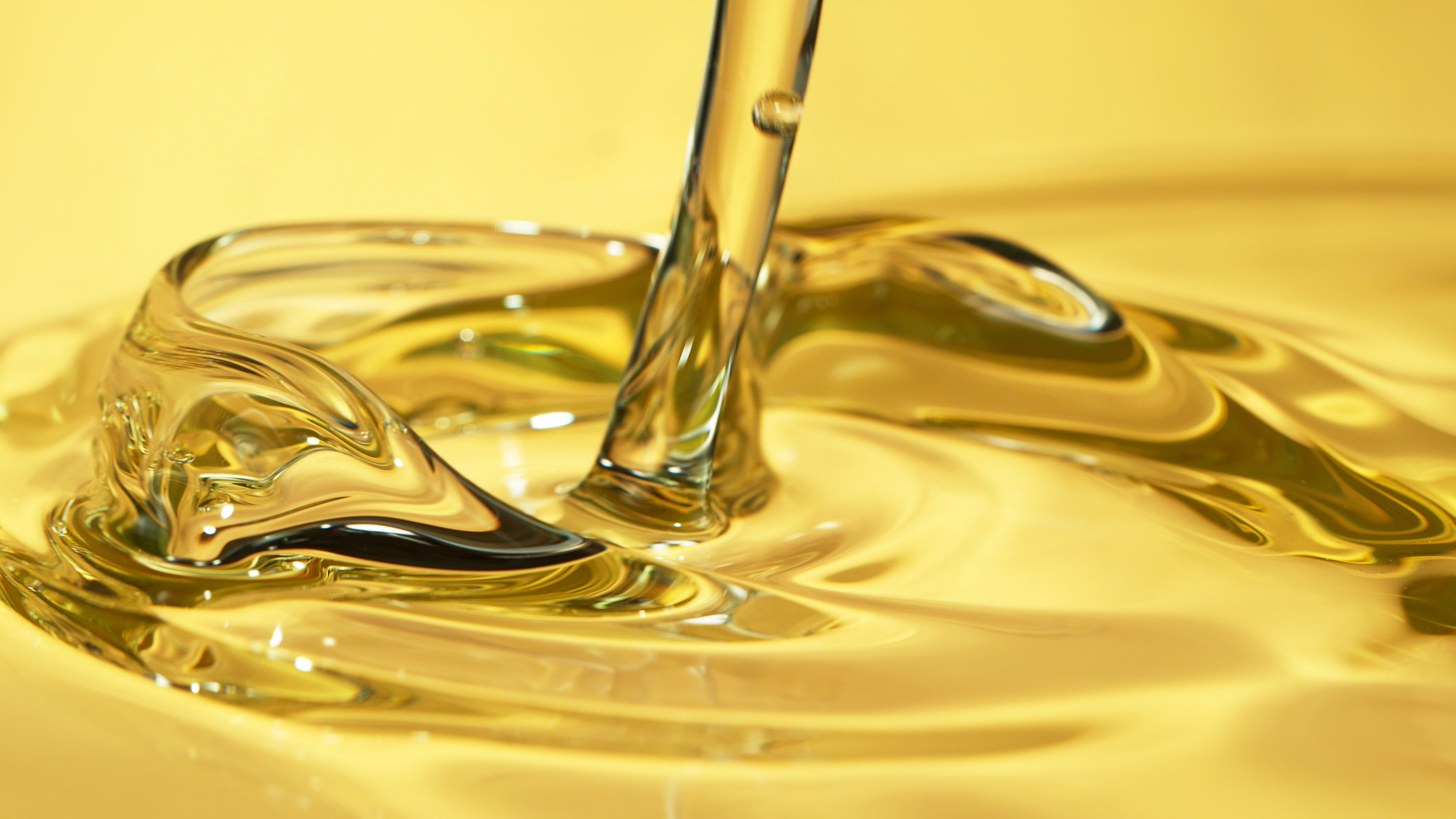 Yellow oil pouring in close-up