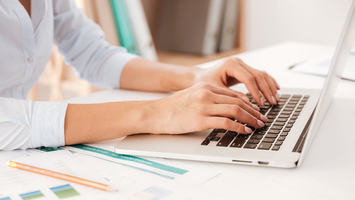 Hands of a woman seen as she types on a laptop - Investors - AAK