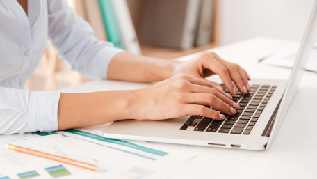 Hands of a woman seen as she types on a laptop - Investors - AAK