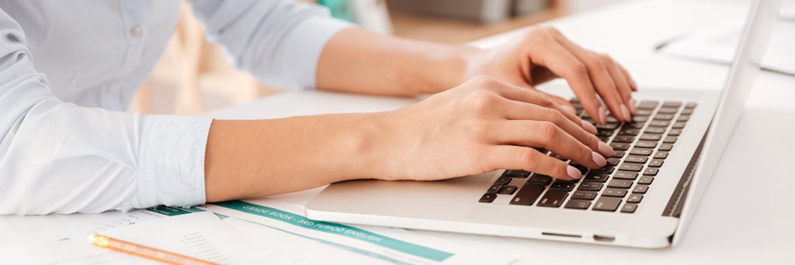 En kvinnas hand när hon skriver på en laptop - Investerare - AAK