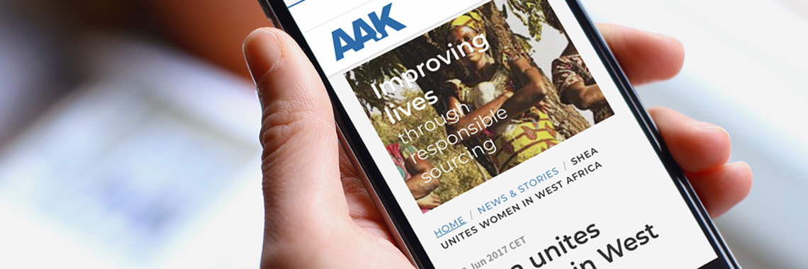 Hand holding a smart phone that displays AAK news article - News & Stories - AAK