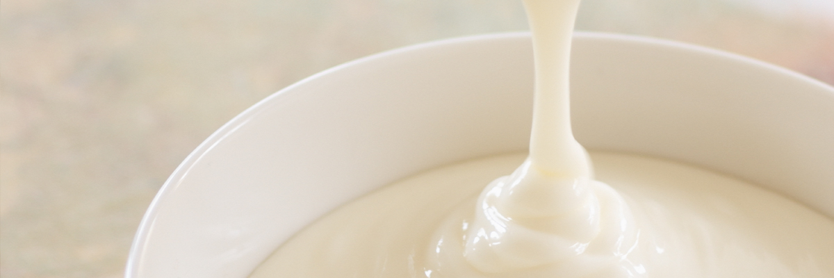 Vegetable fat fluid flowing into white bowl - Co-Development - AAK