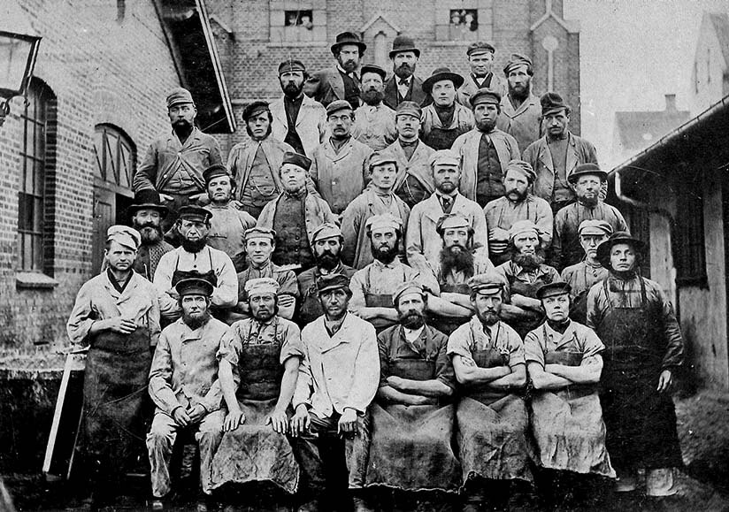 Black-and-white historical photo showing employees standing outside Aarhus Oliefabrik around 1892