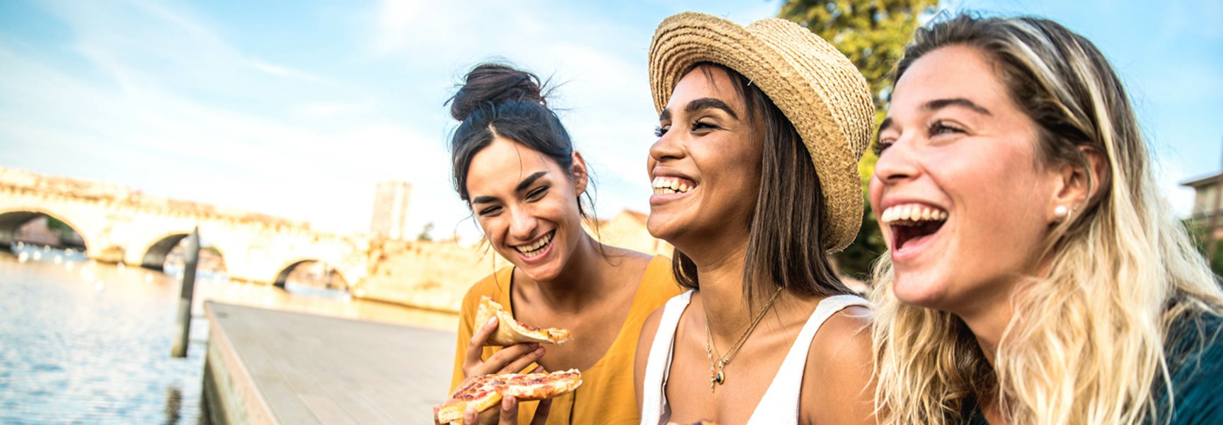 Tjejer som äter en god pizza tillsammans utomhus