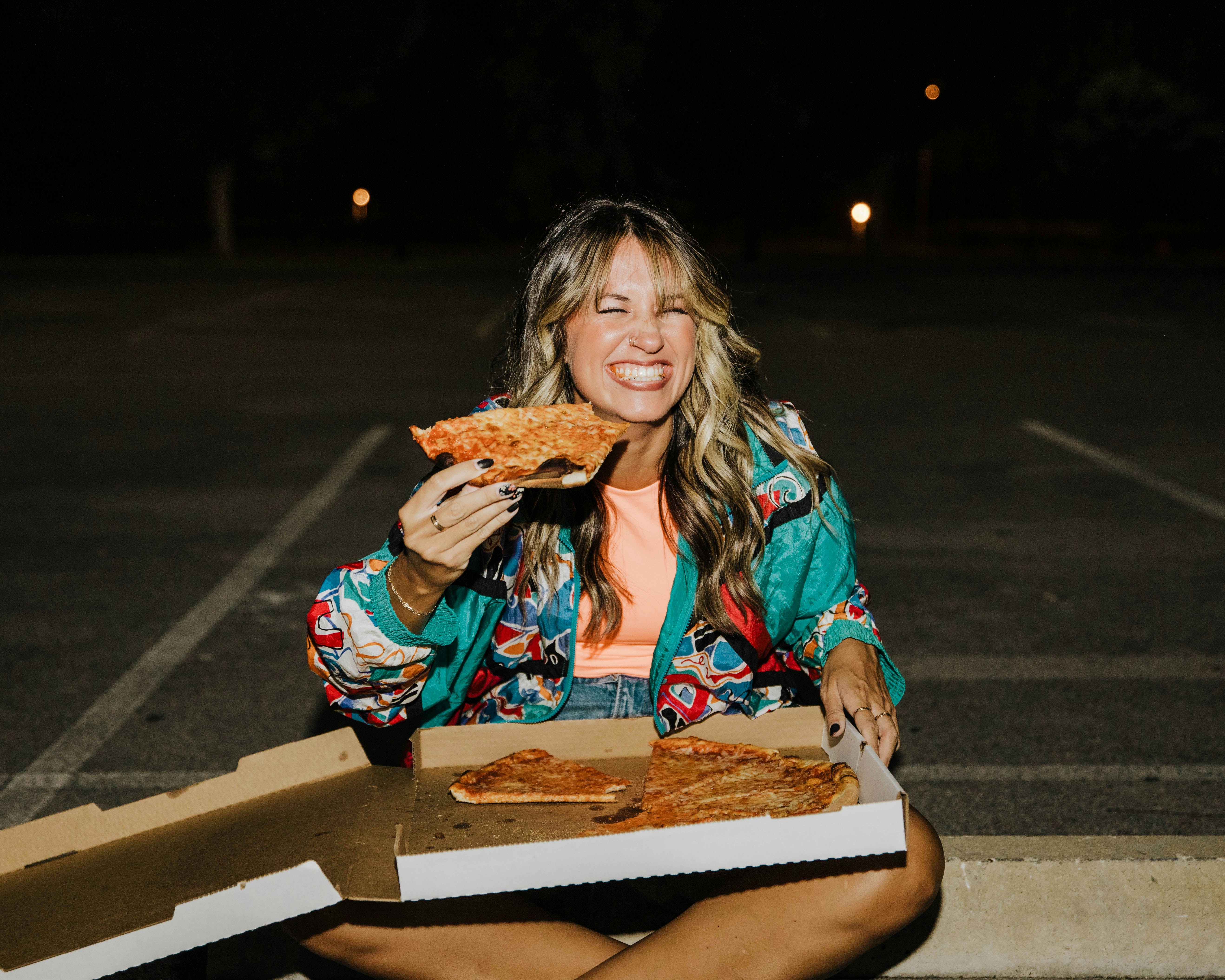 Happy woman eating pizza made with AAK:s Flaked Fat