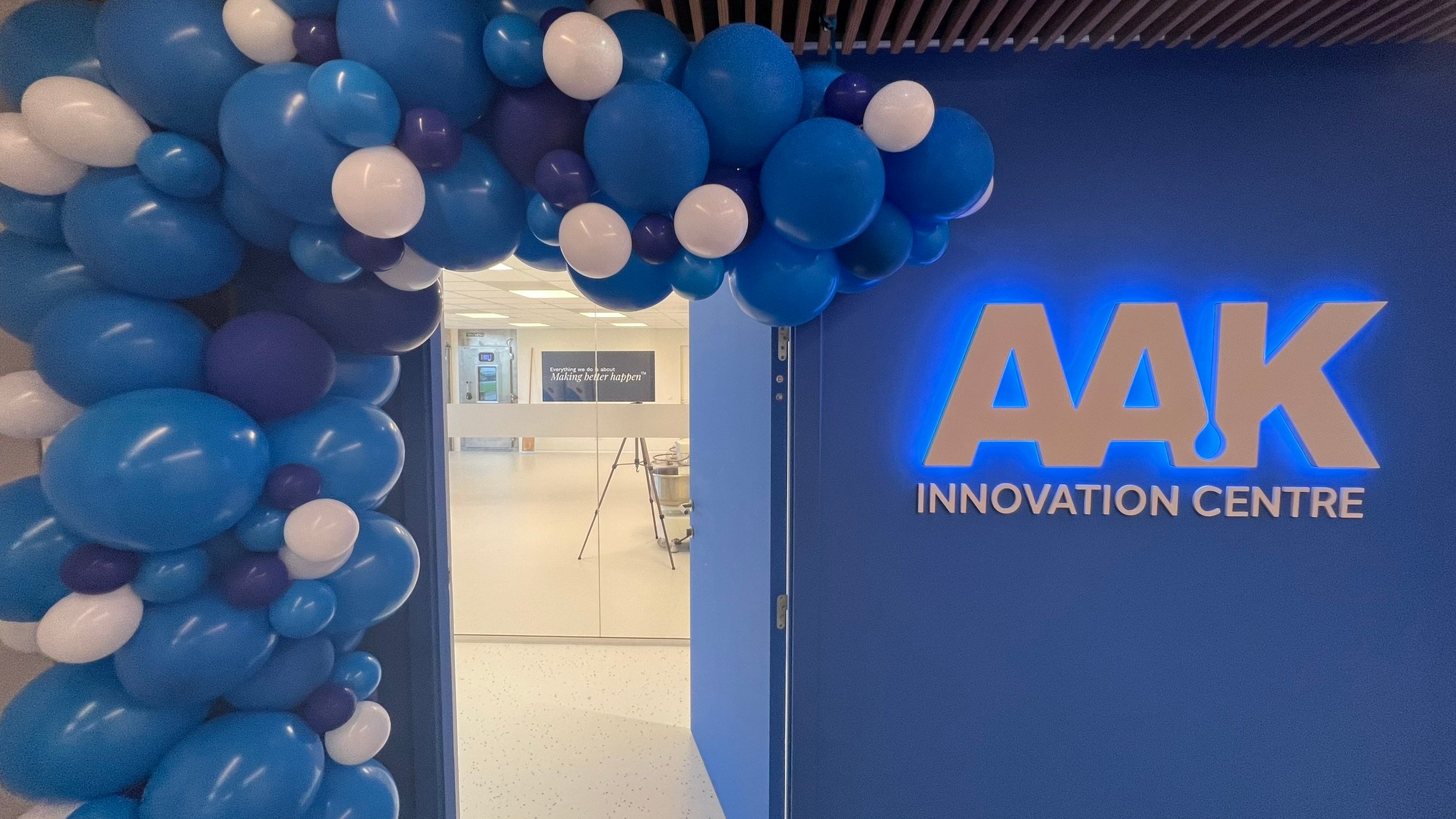 Entrance to AAK Innovation Centre with a balloon arch and illuminated signage.